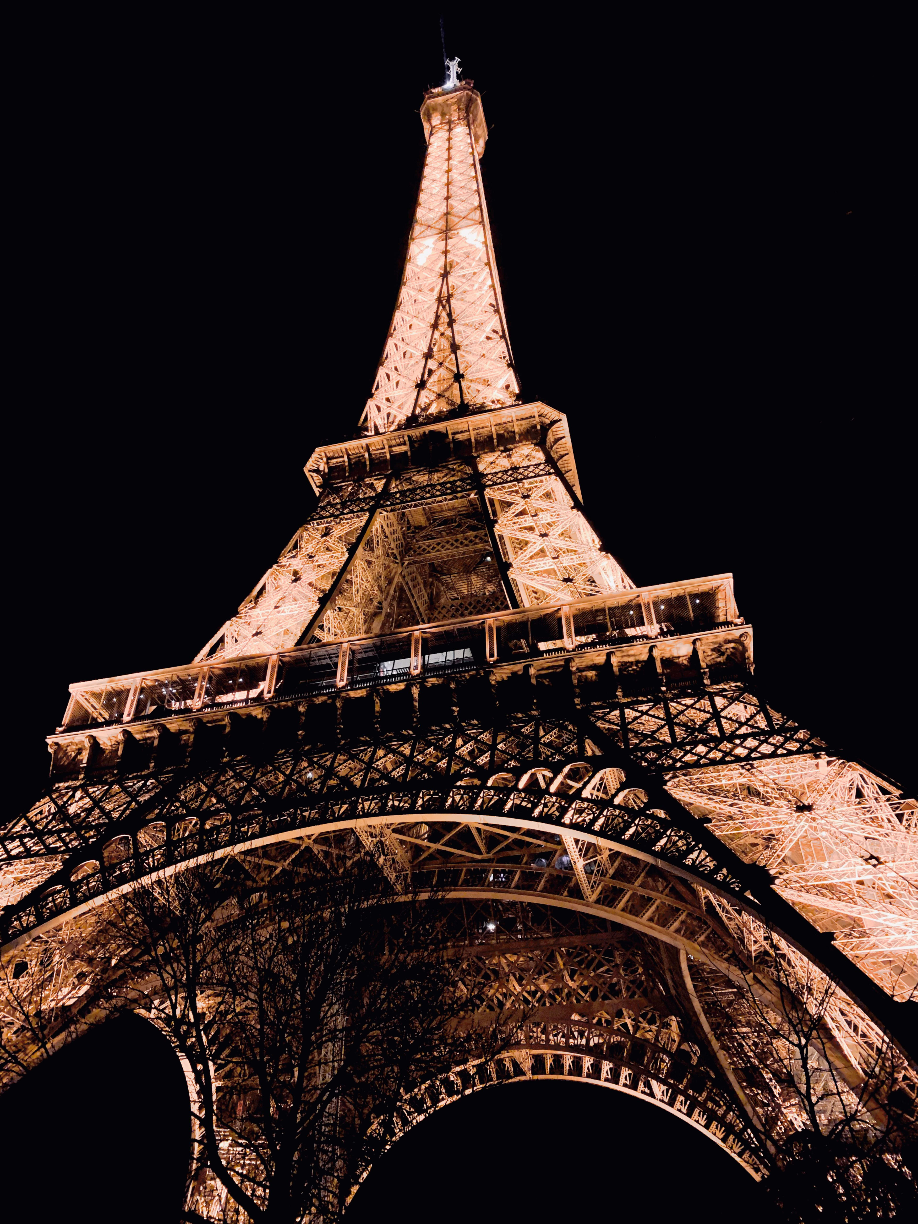 Photograph of the Eiffel Tower in Paris, lit-up against a black sky.