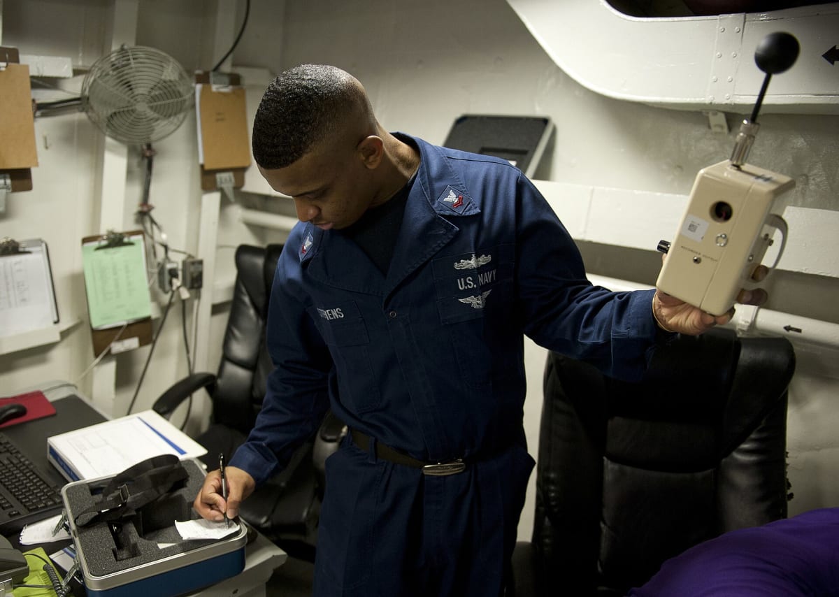 US Navy 120117-N-DR144-136 A Sailor records data from a heat stress monitor to measure temperature