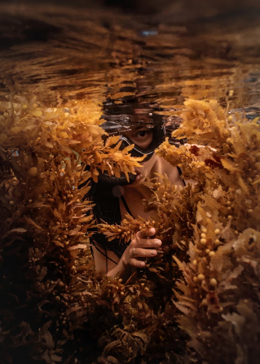 Underwater portrait of a female snorkeler hiding