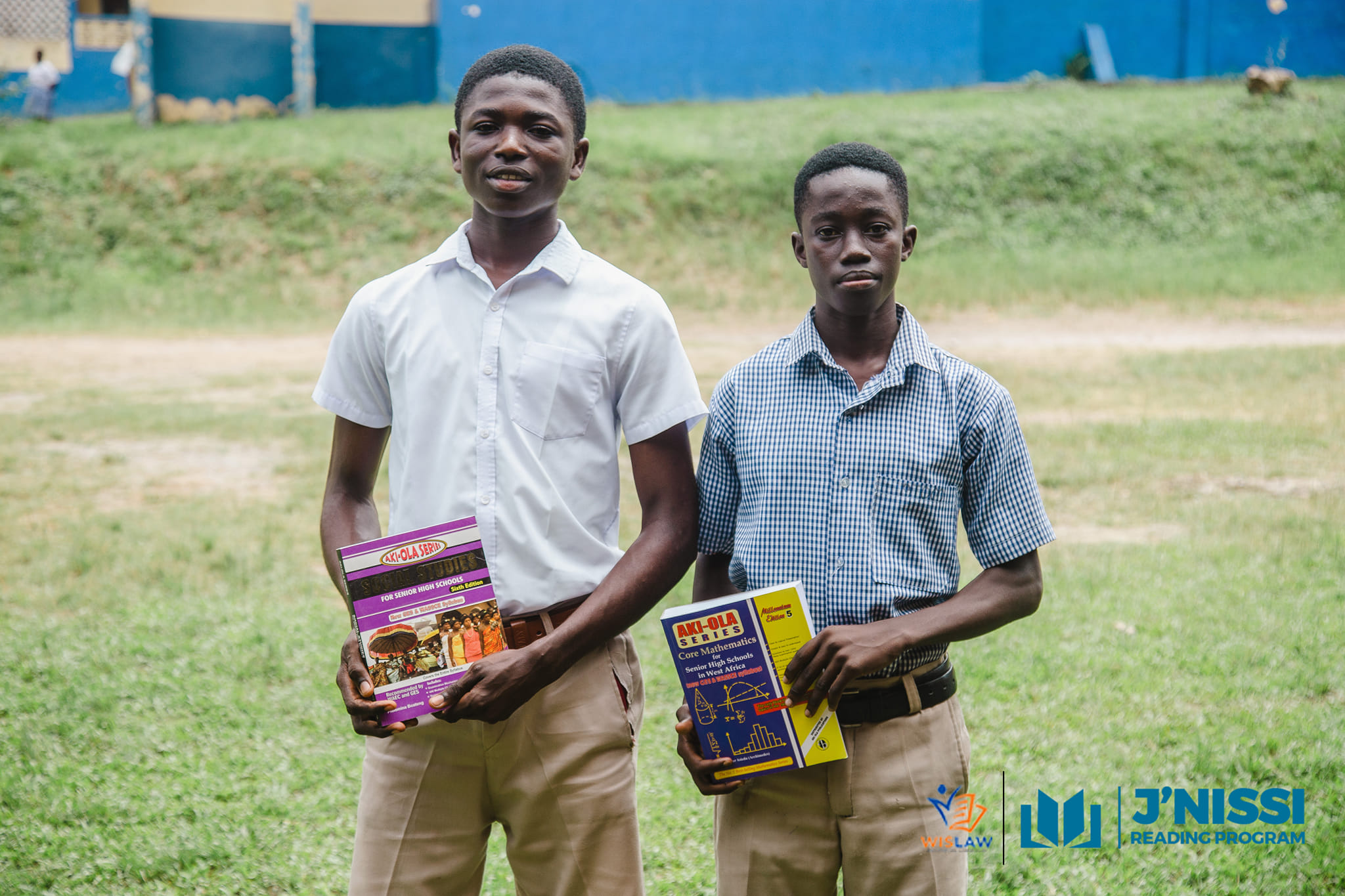 two male students each holding a book
