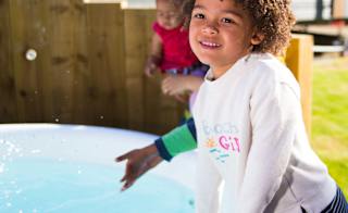 A young child playing near a holiday home hot tub. image