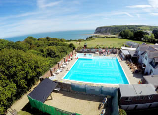 A hot summer's day overlooking our outdoor pool at Whitecliff Bay. Come see for yourself when you visit the Isle of Wight on your next caravan holiday. image