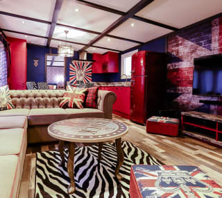 The lounge in our Rockstar holiday home. There’s a spacious kitchen, a large TV and sofa, and a theme of red, white, and blue Great British colours. image