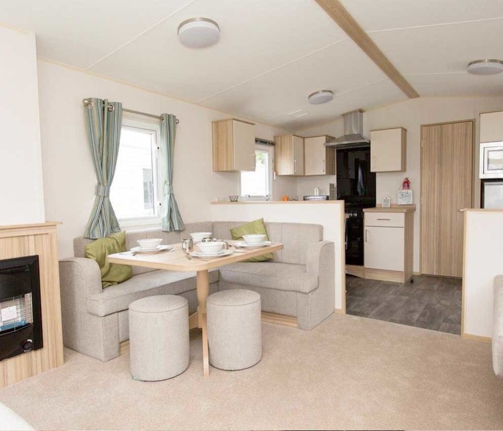 The living and dining area of our bright and spacious comfort static caravan. The perfect way to stay.
