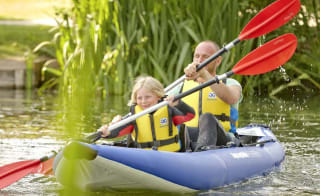 A man and child canoeing down the lake. image