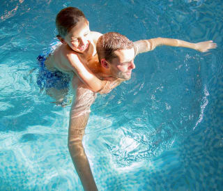 A father and son duo having a swim in one of our indoor pools at our static caravan holiday parks.