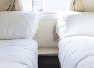 The twin bedroom of one of our budget-friendly value static caravans. The perfect way to stay. image