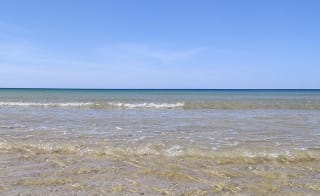 Rolling waves on a bright summers day at a lagoon in Dorset. image