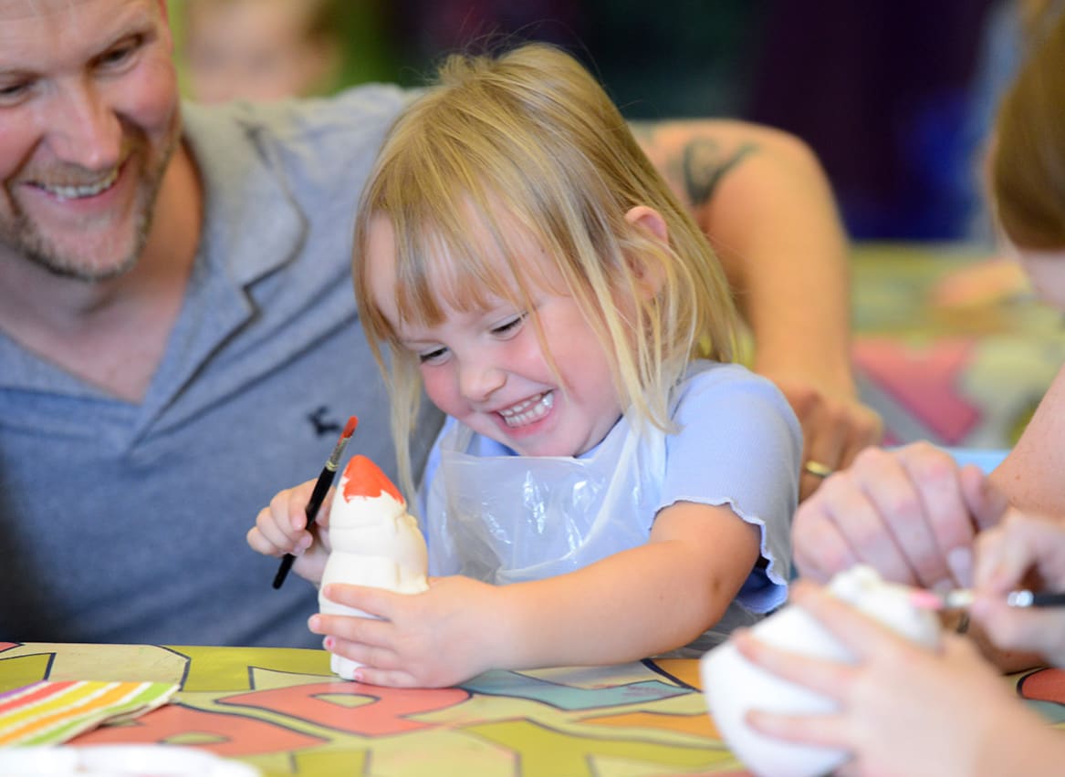 Young girl pottery painting at one of our Away Resorts parks. image