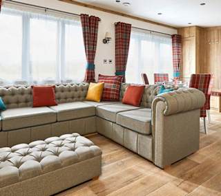The Heartwood holiday home lounge area. This space has a large sofa, a dining area, and décor that reflects Scottish baronial living. image