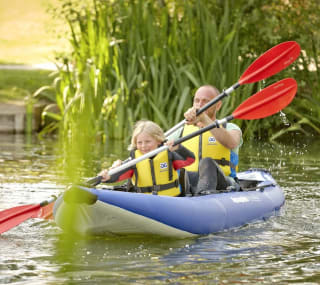 A man and child canoeing down the lake. image