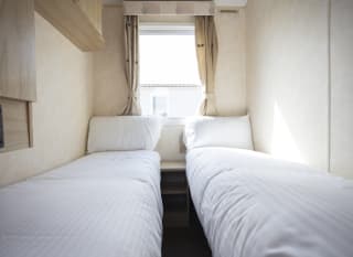 The twin bedroom of one of our budget-friendly value static caravans. The perfect way to stay. image