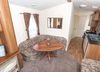 The dining area of our budget-friendly value static caravan. The perfect way to stay. image