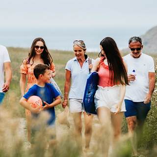 A family enjoying a peaceful stroll to the Cornish coastline on a summers day. image