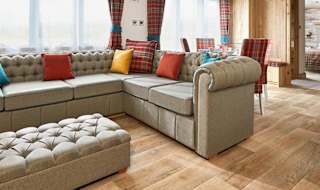 The Heartwood holiday home lounge area. This space has a large sofa, a dining area, and décor that reflects Scottish baronial living. image