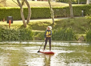 A woman paddleboarding on a sunny day through the lake at our Isle of Wight holiday park, The Lakes Rookley. image