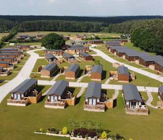 Drone footage above our stunning resort Clumber Park, Nottinghamshire. There are rows of wooden holiday homes perched within stunning woodland scenery.