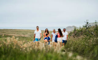A family enjoying a peaceful stroll to the Cornish coastline on a summers day. image