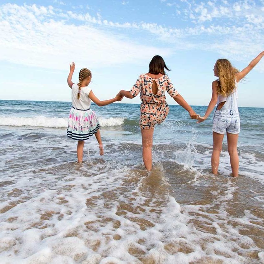 A young family playing in the sea at one of the many beaches in St Ives.