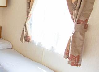 The twin bedroom of our budget-friendly value static caravan. The perfect way to stay. image