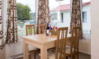 The interior of one of our Superior lodges. There's a dining area with three large windows. image