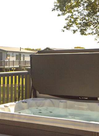 The decking with a hot tub of one of our stunning accommodations at St Helens Coastal Resort.