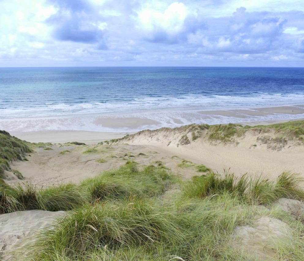 An image of the beach and sea from the South West Coastal Path.