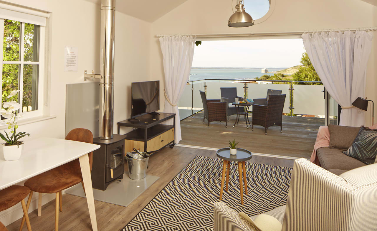 The living area of one of our spacious Beach Lodges, with stunning views of the sea from the balcony. Book your holiday now! image