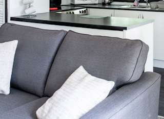 The interior of one of our Comfort holiday lodges. There's a large grey sofa, dining area, and spacious kitchen. image