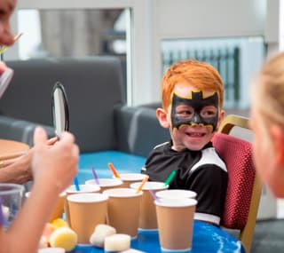 Two young children enjoying one of our awesome on-site activities, the Superhero Academy. image