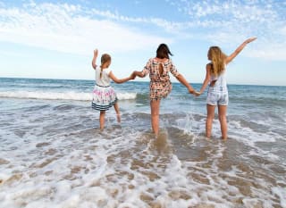 A young family playing in the sea at one of the many beaches in St Ives. image