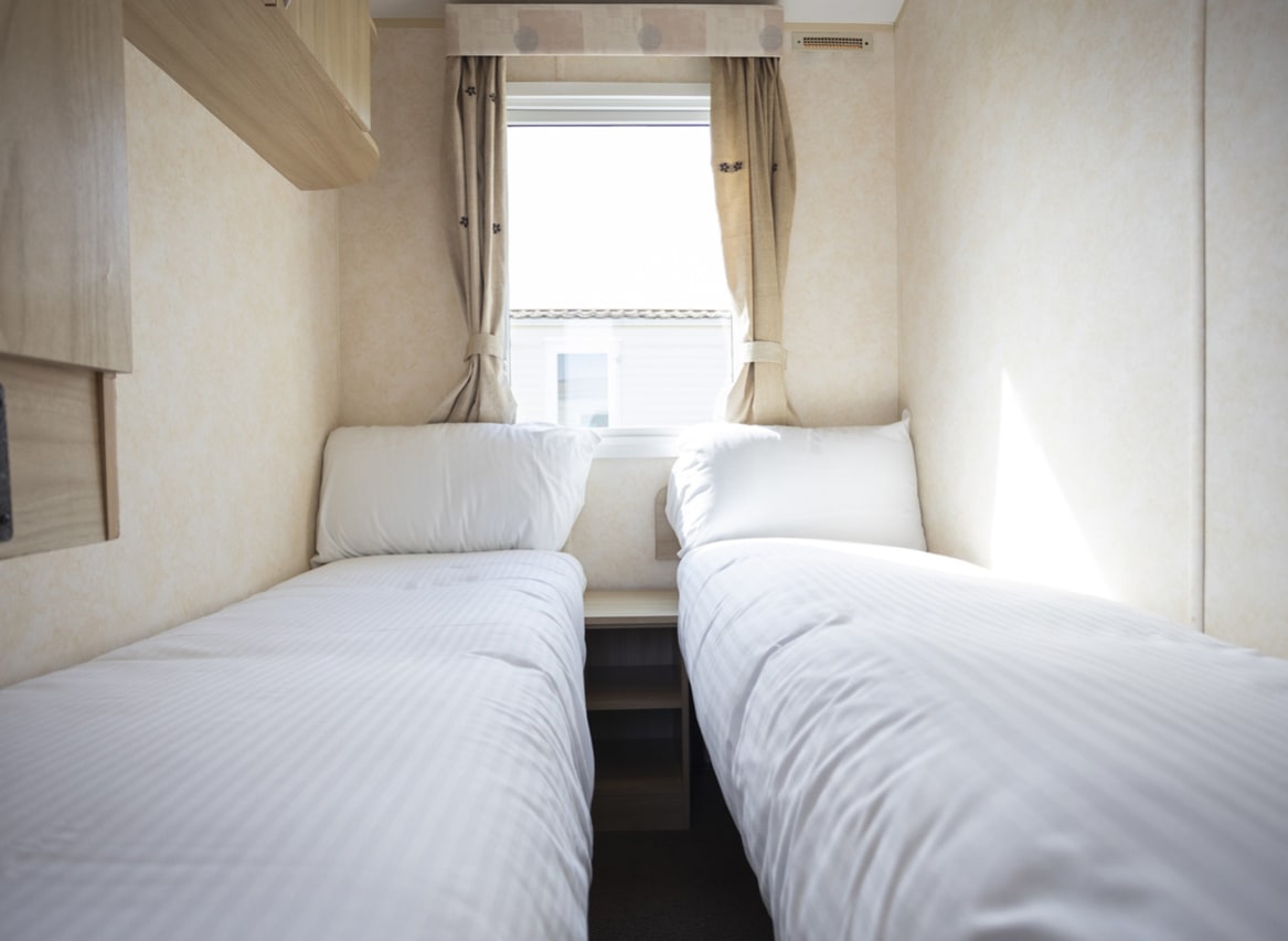 The twin bedroom of one of our budget-friendly value static caravans. The perfect way to stay. image