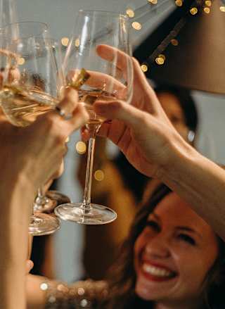 A group of people cheersing with glasses of wine.