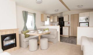 The living and dining area of our bright and spacious comfort static caravan. The perfect way to stay. image