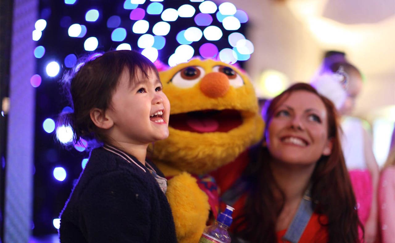 A young girl enjoying our awesome entertainment with one of our cuddly characters, Lucy. image