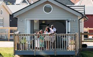 A family on the decking looking out onto the lake at our stunning resort, The Bay Filey. image