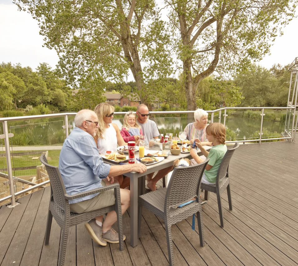 A family sat in the outdoor seating area at The Lakeside Bar & Eatery on a summers day at our park in the Isle of Wight, The Lakes Rookley. image