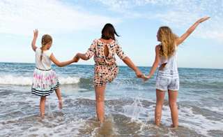 A young family playing in the sea at one of the many beaches in St Ives. image