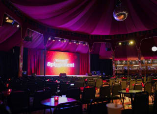 Interior of our Spiegaltent, with a large screen which reads,