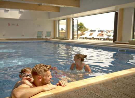 A young family enjoying a swim in the pool at our stunning park, The Bay Colwell.