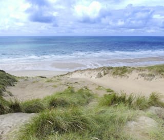An image of the beach and sea from the South West Coastal Path.
