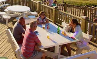 The outdoor eating area of our restaurant at St Ives Bay Holiday Park, with views of the sea. image