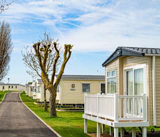 A row of caravans at our park in Essex, Mersea Island on a sunny, cloudy day.