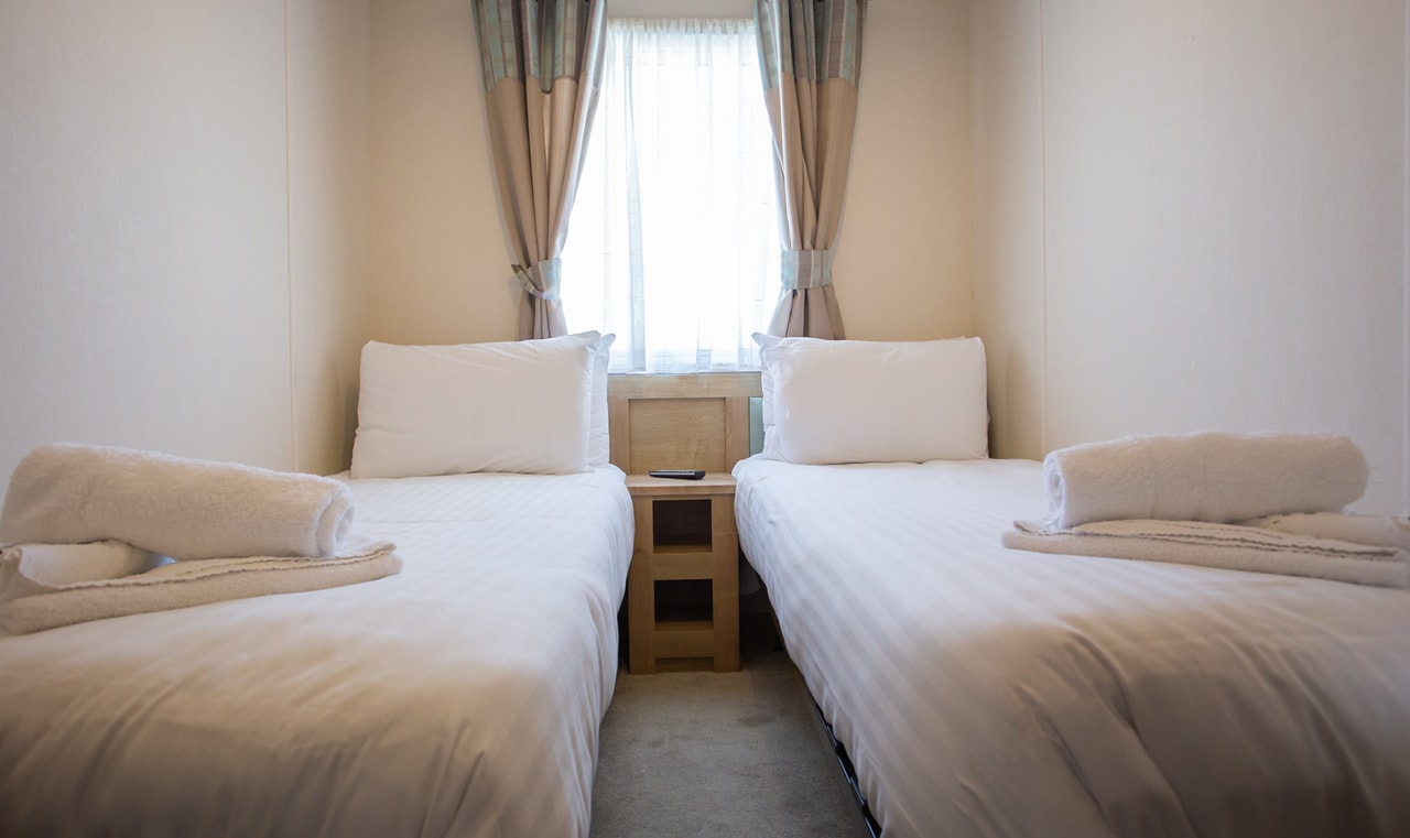 The twin bedroom at one of our bright and spacious indulgent static caravans. The perfect way to stay. image