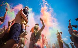 A young family enjoying the colour dash festival on a bright sunny day. We offer this and many more fun events at our Whitecliff Bay holiday park. image