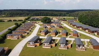 Drone footage above our stunning resort Clumber Park, Nottinghamshire. There are rows of wooden holiday homes perched within stunning woodland scenery.