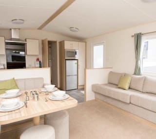 The living and dining area of our bright and spacious comfort static caravan. The perfect way to stay. image