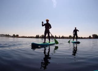A photo of two people paddle boarding in the calm lake at our Tattershall Lakes holiday park. image
