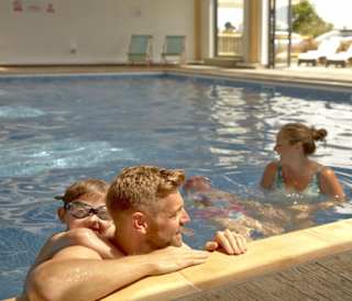 A young family enjoying a swim in the pool at our stunning park, The Bay Colwell.