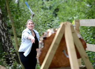 A lady taking part in the target axe throwing activity. image